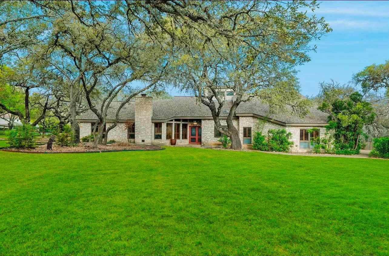 The home’s exterior before its white finish, seen from across the lawn.