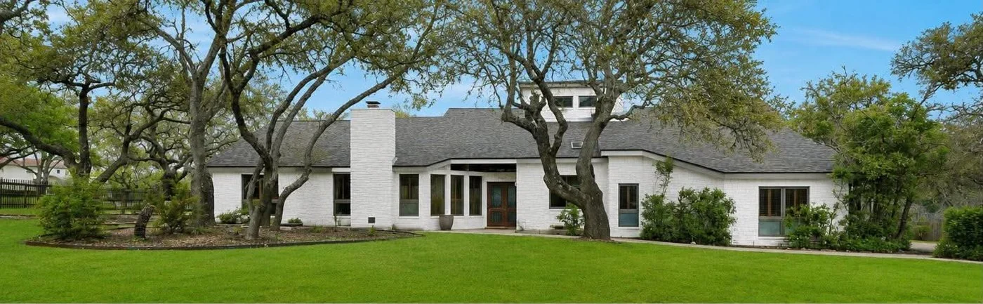 The same property with white masonry and contrasting dark trim, photographed from a different viewpoint.