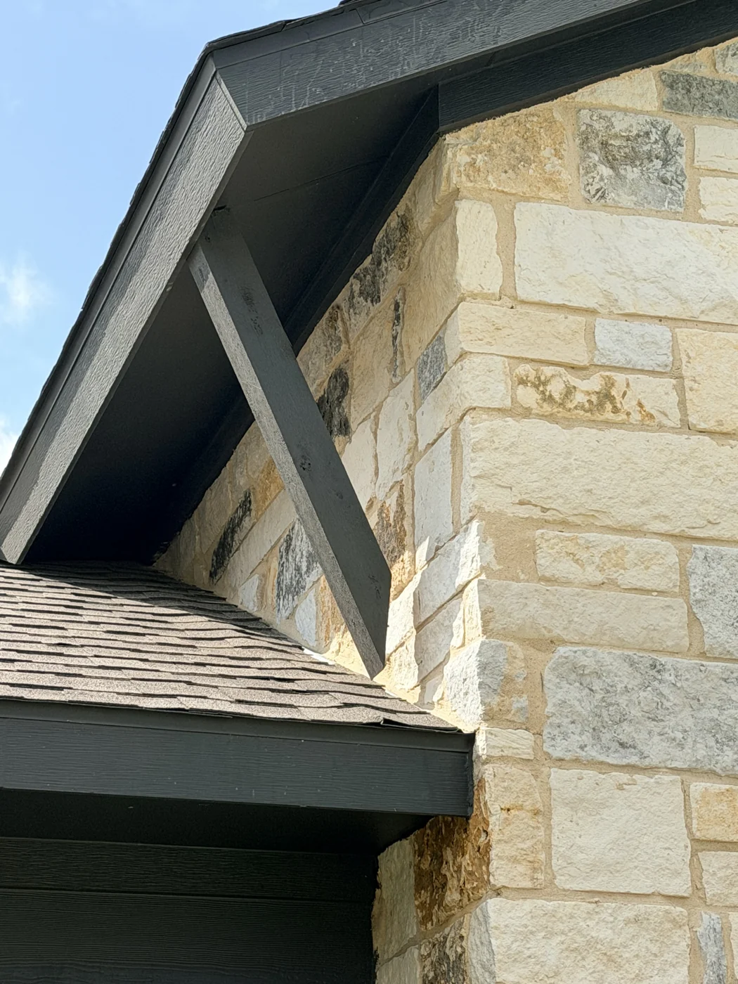 A close look at natural stone, dark soffits and the roofline on a client-supplied exterior project.