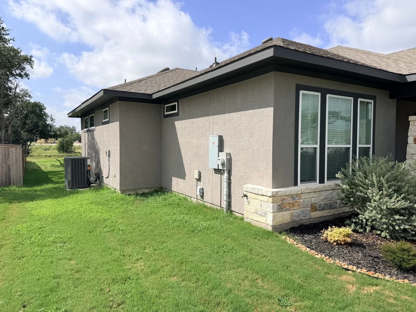 A view of the exterior walls, windows and roofline from the lawn.