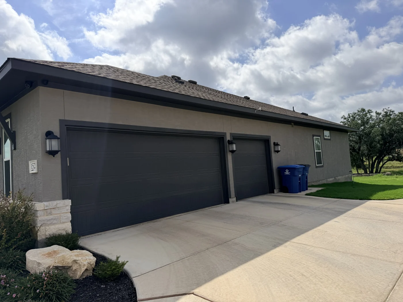 Dark garage doors and trim alongside the home’s exterior finish.