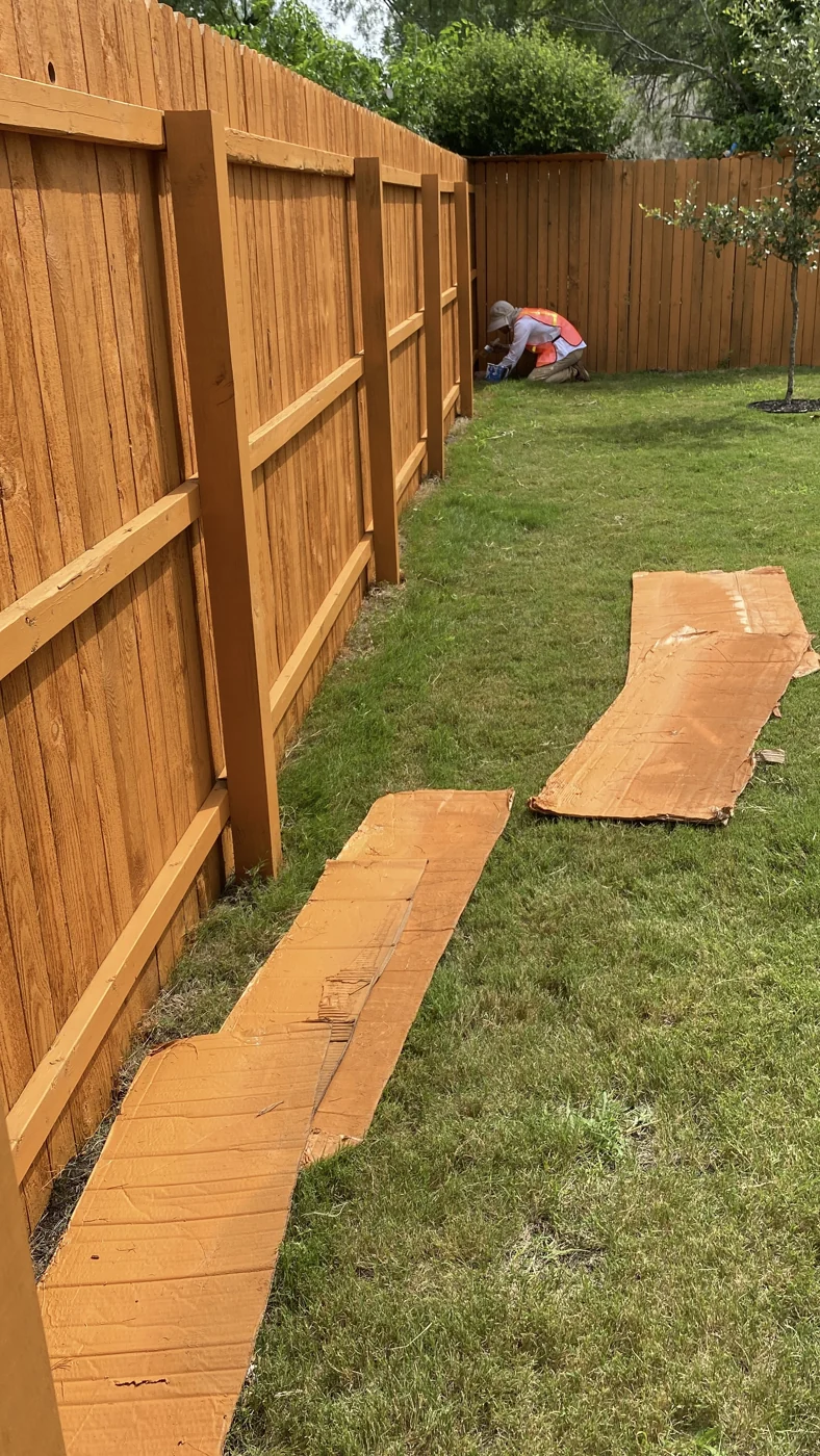 A closer view of timber fence boards, rails and adjoining lawn.
