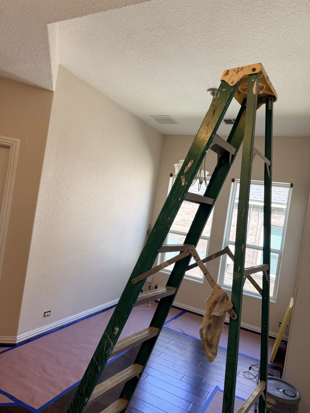 Floor coverings and taped edges protect the surrounding surfaces while the room is prepared.