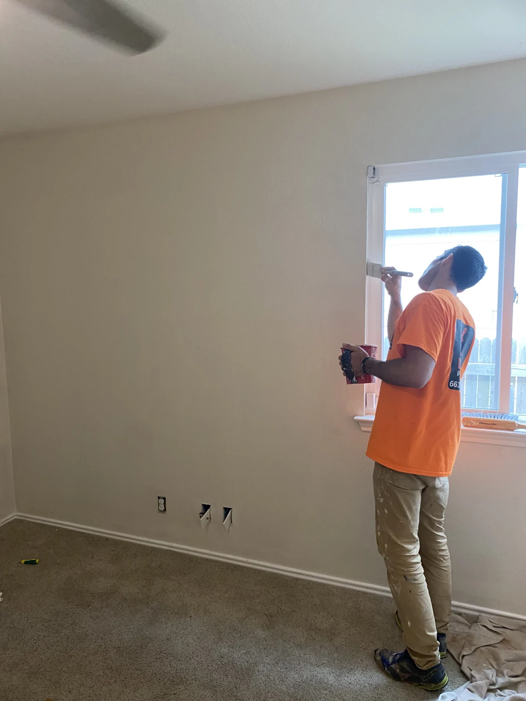A crew member working beside a window during an interior project.