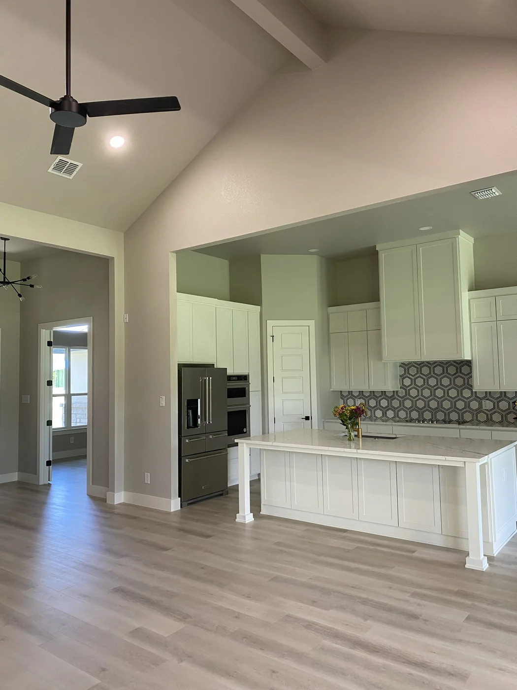 A view across the completed living space toward the kitchen and painted cabinetry.