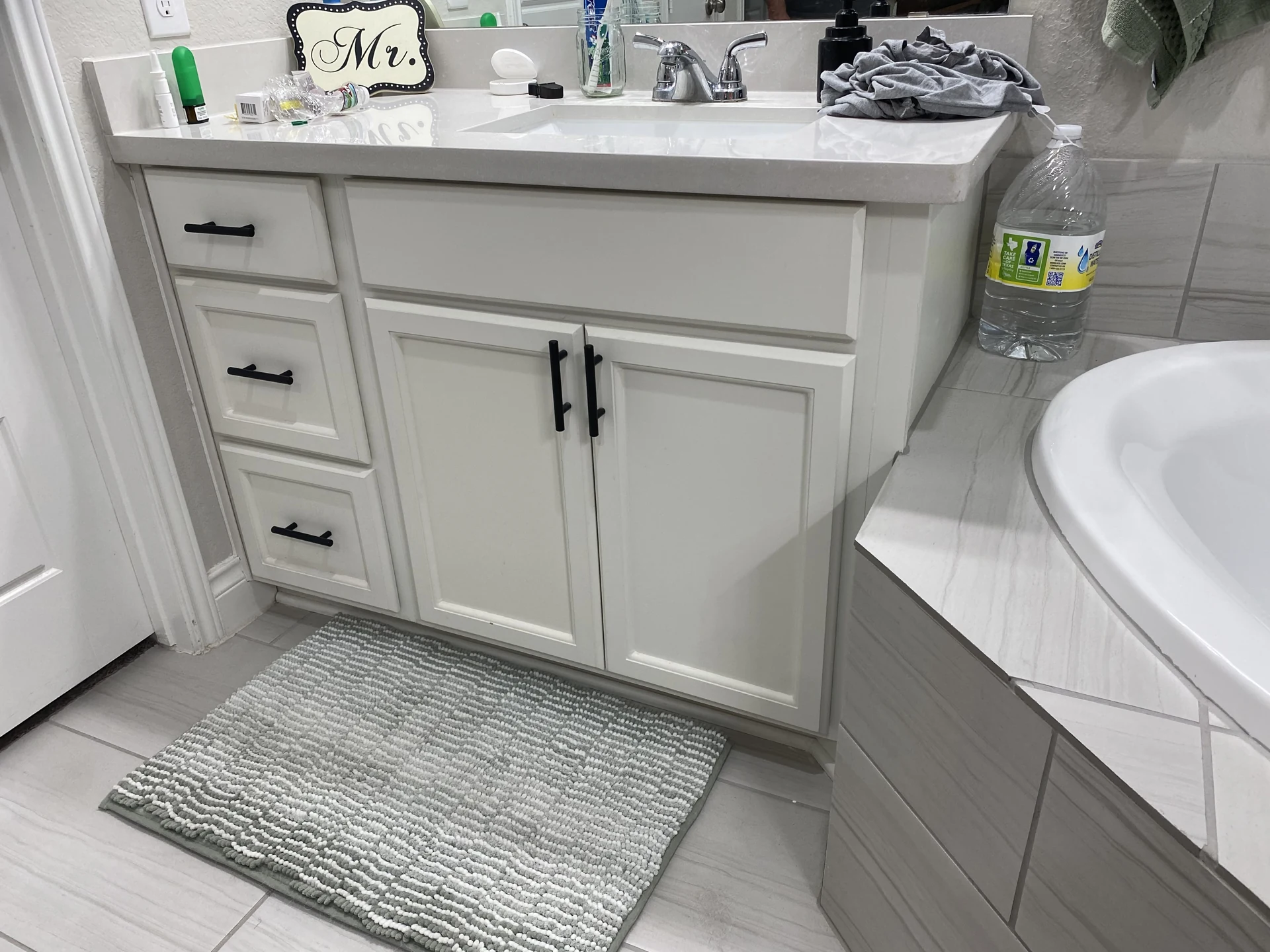 Light painted bathroom cabinetry with paneled doors and drawers